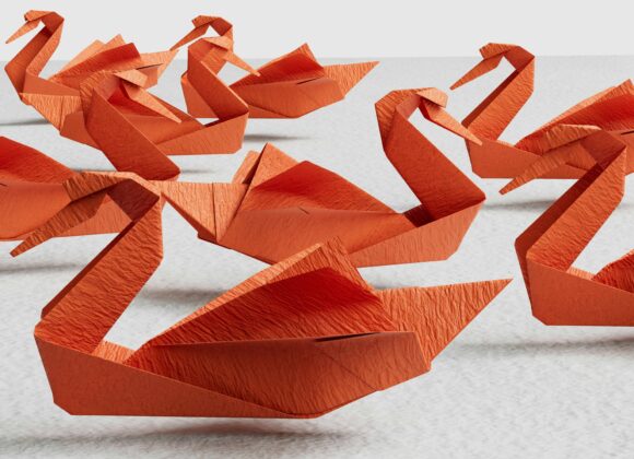 a group of orange origami swans sitting on top of a table