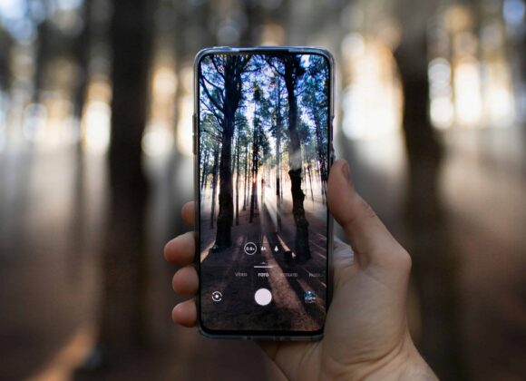 person holding black smartphone taking photo of city lights during night time